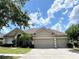 One-story house with three-car garage and manicured lawn at 142 Winghurst Blvd, Orlando, FL 32828