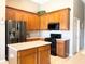 Kitchen with island, wood cabinets and stainless steel appliances at 142 Winghurst Blvd, Orlando, FL 32828