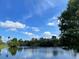 Tranquil lake view reflecting trees and sky at 142 Winghurst Blvd, Orlando, FL 32828