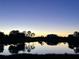 Serene lake view at sunset with trees reflecting in the water at 142 Winghurst Blvd, Orlando, FL 32828