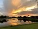 Stunning sunset over peaceful lake with homes reflecting in water at 142 Winghurst Blvd, Orlando, FL 32828