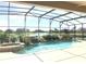 Enclosed pool and spa area with waterfall feature and lake view at 142 Winghurst Blvd, Orlando, FL 32828