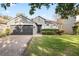 Gray house with 2-car garage, manicured lawn, and brick driveway at 1449 Ashdown Ct, Sanford, FL 32771