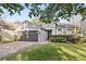 Gray house with 2-car garage, manicured lawn, and brick driveway at 1449 Ashdown Ct, Sanford, FL 32771