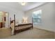 Bedroom with a wooden post bed and large window at 148 Calliope St, Ocoee, FL 34761