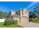 Two-story house with a three-car garage and lush landscaping at 148 Calliope St, Ocoee, FL 34761