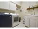 Bright laundry room with washer, dryer, cabinets, and sink at 148 Calliope St, Ocoee, FL 34761