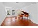 Living room with hardwood floors and a grand piano at 148 Calliope St, Ocoee, FL 34761