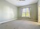 Bedroom with grey carpet and window with curtains at 1480 Battle St, Oviedo, FL 32765