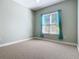 Simple bedroom featuring light walls, carpet flooring, and a window with teal curtains at 1480 Battle St, Oviedo, FL 32765