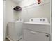 Bright laundry room, featuring a washer and dryer, and overhead shelving at 1552 Carey Palm Cir, Kissimmee, FL 34747