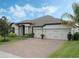 Exterior view of a single-Gathering home with a three-car garage and landscaping at 17608 Sailfin Dr, Orlando, FL 32820