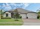 Exterior view of a single-Gathering home with a three-car garage and landscaping at 17608 Sailfin Dr, Orlando, FL 32820