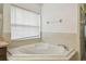 Relaxing bathroom with corner tub and window at 2058 Newtown Rd, Groveland, FL 34736