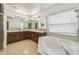 Bathroom boasts a large corner soaking tub and double vanity at 2058 Newtown Rd, Groveland, FL 34736