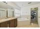 Main bathroom with double vanity, corner tub, and view to the bedroom at 2058 Newtown Rd, Groveland, FL 34736