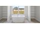 Elegant bathroom features a freestanding bathtub and built-in shelving at 208 Snowy Orchid Way, Lake Alfred, FL 33850