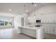 Modern kitchen with white cabinets, quartz countertops, and pendant lighting at 208 Snowy Orchid Way, Lake Alfred, FL 33850