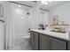 Modern bathroom with gray vanity, white tile, and white curtains at 2338 Gold Dust Dr, Minneola, FL 34715