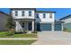 Two-story house with gray siding, white trim, and a two-car garage at 2338 Gold Dust Dr, Minneola, FL 34715