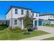 Two-story house with gray and white exterior, teal garage doors, and landscaping at 2338 Gold Dust Dr, Minneola, FL 34715