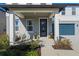 Covered front porch with modern entry door and potted plants at 2338 Gold Dust Dr, Minneola, FL 34715