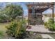 Relaxing backyard patio with pergola, seating area, and lush landscaping at 2368 Monaco Cove Cir, Orlando, FL 32825