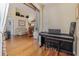 Living room with hardwood floors, piano and view into the kitchen at 2368 Monaco Cove Cir, Orlando, FL 32825