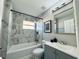 Updated bathroom with marble-look tile, gray vanity, and bathtub at 2413 Rock Ct, Poinciana, FL 34759