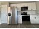 Stainless steel appliances and white shaker cabinets in the kitchen at 2413 Rock Ct, Poinciana, FL 34759