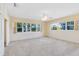 This main bedroom features large windows for natural light, plush carpeting, and a ceiling fan at 280 E Constance Rd, Debary, FL 32713