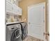 Laundry room with washer, dryer, and ample cabinet storage space at 2950 Sonata Ct, Saint Cloud, FL 34772