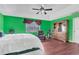 Green bedroom with king bed, armoire, and wood floors at 2988 Stillwater Dr, Kissimmee, FL 34743