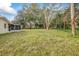 Spacious backyard with mature trees and screened porch at 332 Lake Winnemissett Dr, Deland, FL 32724