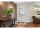 Bright and airy entryway with hardwood floors, textured wall, and console table at 332 Lake Winnemissett Dr, Deland, FL 32724