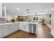 Open kitchen with white cabinets, island, and farmhouse sink at 332 Lake Winnemissett Dr, Deland, FL 32724