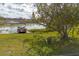 Relaxing lakefront view with two chairs and a pontoon boat at 332 Lake Winnemissett Dr, Deland, FL 32724