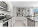 Modern kitchen featuring white cabinets, granite countertops, and stainless steel appliances at 3472 Sandalwood Isle Way, Ocoee, FL 34761