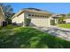 Single car garage with light beige door and landscaping at 5119 Santa Ana Dr, Orlando, FL 32837