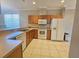 Kitchen with wood cabinets, white appliances, and tile floors at 5119 Santa Ana Dr, Orlando, FL 32837