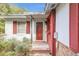 Red front door entrance with brick steps and red shutters at 5217 N Apopka Vineland Rd, Orlando, FL 32818