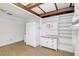 White kitchen with wood beam ceiling, tiled floor, and ample storage at 5217 N Apopka Vineland Rd, Orlando, FL 32818