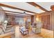 Spacious living room featuring hardwood floors, exposed wooden beams, and a brick fireplace at 5217 N Apopka Vineland Rd, Orlando, FL 32818