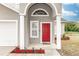 Inviting front entrance with a red door, arched entryway, and landscaping at 587 Bluff Pass Dr, Eustis, FL 32726