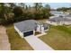 Aerial view of a modern one-story home, showcasing its well-manicured lawn, stylish roof, and concrete driveway at 6579 Sw 132Nd St, Ocala, FL 34473