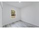 Simple bedroom with modern light gray floors, white walls, and a window with natural light at 6579 Sw 132Nd St, Ocala, FL 34473