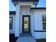 Modern front entrance with glass and wood door, sleek design, and pendant light at 6579 Sw 132Nd St, Ocala, FL 34473