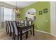 Formal dining room with a large table, green accent wall, and kitchen views at 7773 Basnett Cir, Kissimmee, FL 34747