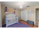 Well-lit Bedroom with a crib, closet, and decorative wall art at 7927 Oakstone Ct, Orlando, FL 32822