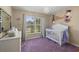 Charming Bedroom features a crib, dresser, and large window at 7927 Oakstone Ct, Orlando, FL 32822